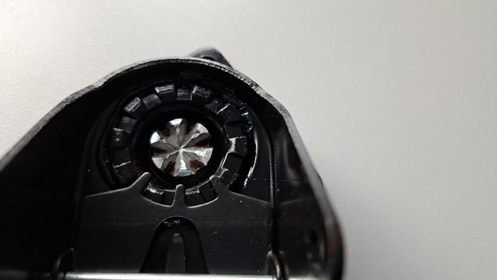 Close-up of reddish-brown corrosion spots around the central mounting interface of a zinc-plated castor housing