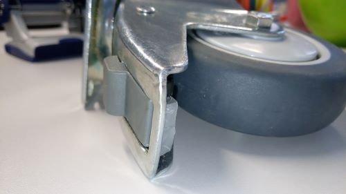 Braked castor showing the brake pedal and housing area