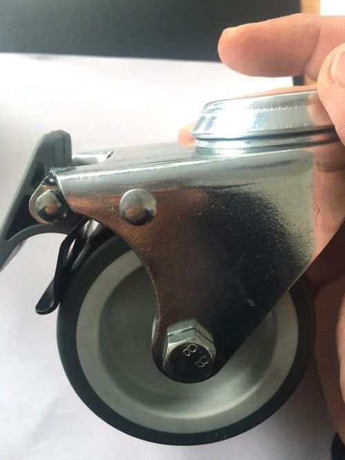 Braked castor assembly showing the pedal, swivel housing and wheel